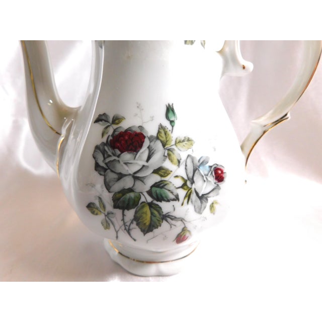 This is a white Winterling teapot in the Bavarian Rose pattern. I do not have date for the pattern. It has a grey rose...