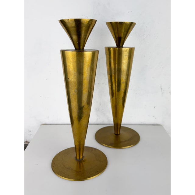 Pair of vintage Italian brass candlesticks featuring a striking Mid-Century Modern conical design. Crafted from spun...