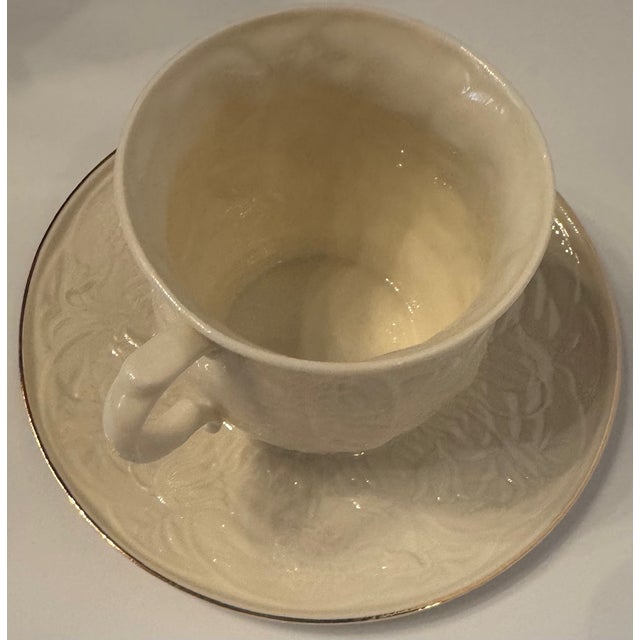 Antique Belleek Ireland porcelain cup and saucer featuring a sculptural raised relief pattern and soft ivory glaze....