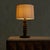 A French table lamp from the 1950s, attributed to Charles Dudouyt. The turned wooden base rises in a spiraling rhythm of...