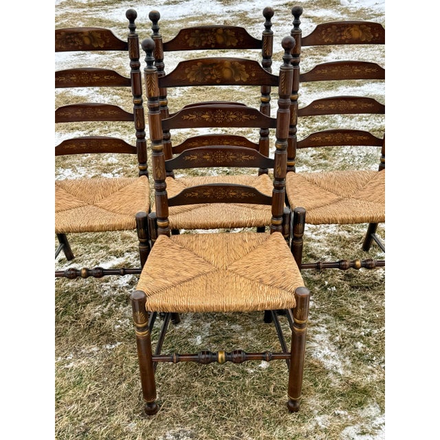 Lovely set of vintage Hitchcock chairs featuring a Ladderback design with woven rush seats and turned legs and stretcher....