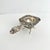 Repousse cherub tea strainer with a BBR or BRB monogram. This piece is stamped Italy but has the faint German silver half...