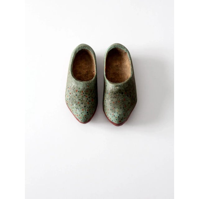 Pair of antique wooden clogs, hand-carved and hand-painted decorative shoes in a small children’s size. These charming...