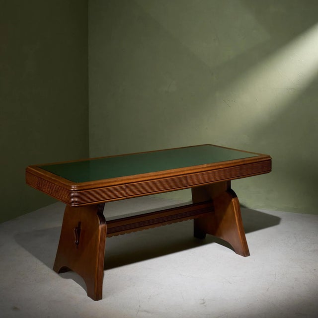 This Italian desk from the 1940s is constructed from solid and veneered chestnut. The desk features a "grissinato" carved...