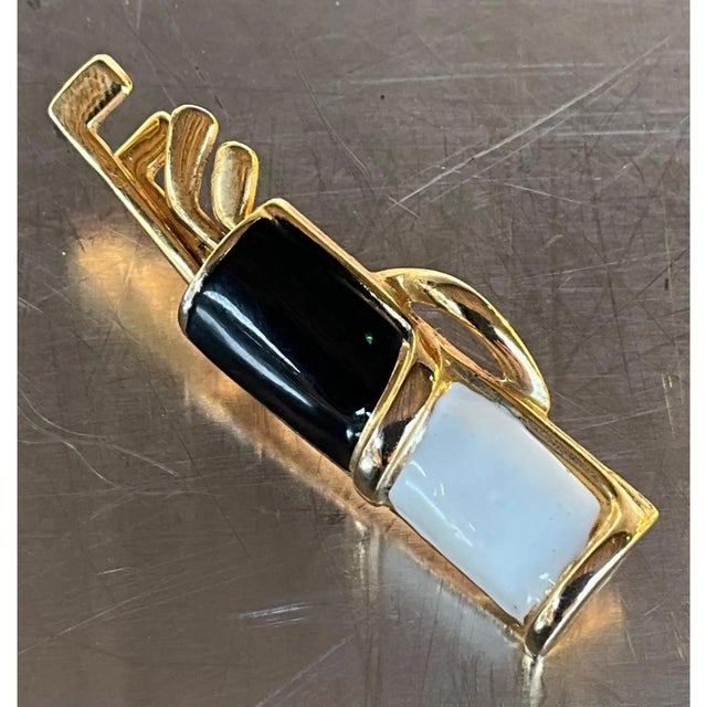 This vintage brooch takes the whimsical form of a golf bag complete with clubs, rendered in gold-tone metal with bold...