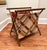 Simple organic materials of fabric and wood comprise this vintage sewing basket. A bold, criss cross pattern in colors of...