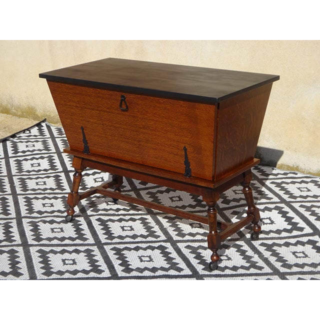 A chest of drawers-style storage unit, a rolling trunk with a wide front opening. Vintage-style furniture in oak and black...
