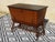 A chest of drawers-style storage unit, a rolling trunk with a wide front opening. Vintage-style furniture in oak and black...