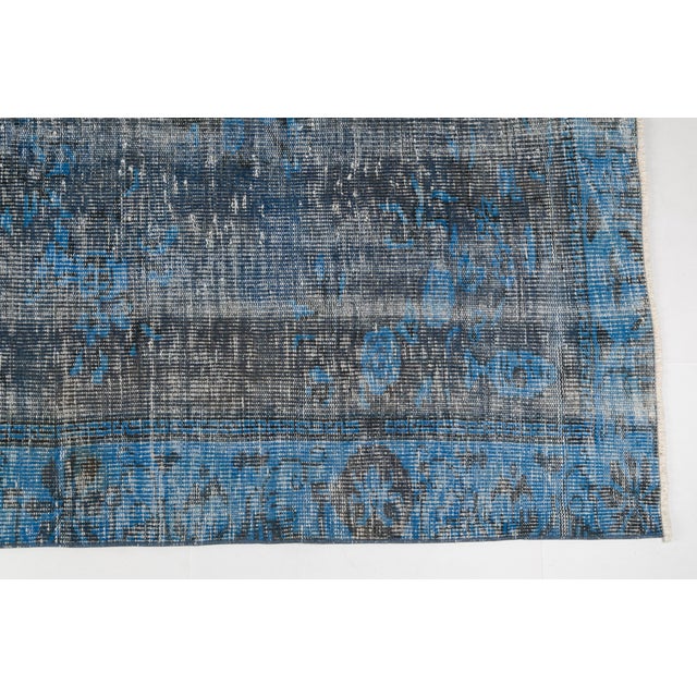 This is a vintage Turkish Oushak rug from the Mid 20th Century. The piece was hand-knotted.