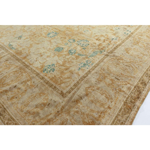 A late 19th-century Indian antique rug, the golden yellow field with a lush overall design of flowering vines around a...