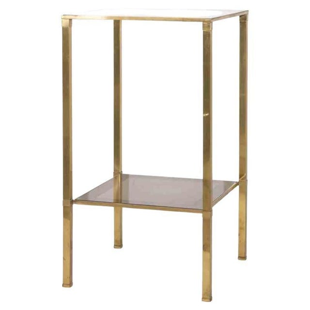 Vintage Bedside Table is an original design item realized in the 1970s. An elegant brass table with two shelves in glass.