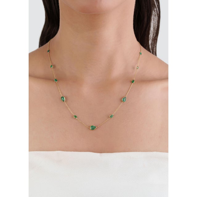 This modern station necklace showcases 3.4 carats of natural Zambian emeralds, set in 14K yellow gold. The pear shaped...