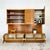 Teak-veneered modular wall unit system comprising two base cabinets and two wall-mounted upper cabinets. Each base unit...