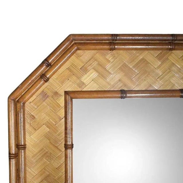 An octagonal faux bamboo and rattan wall mirror by American of Martinsville. A superb example of Hollywood Regency design,...