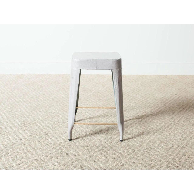 Leather covered metal stool with brass foot bars. Storm full grain leather.