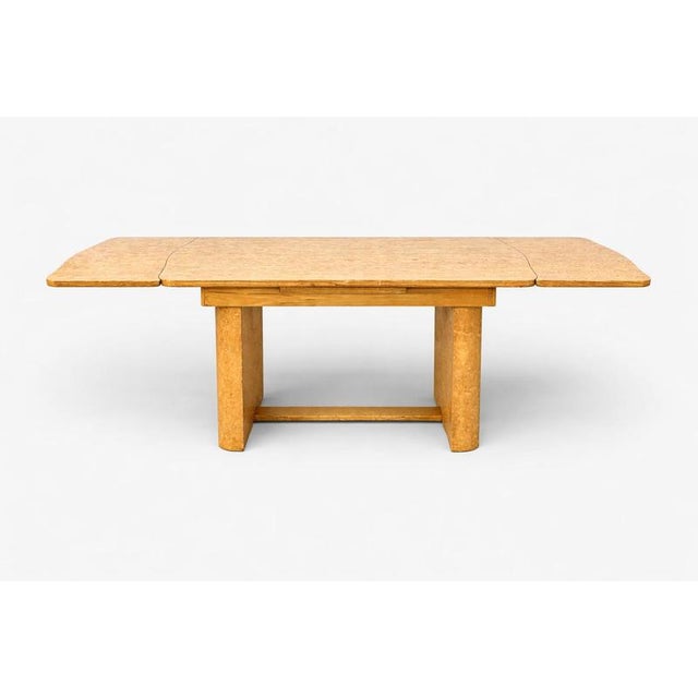 A striking Art Deco extending dining table crafted in maple, dating from the 1930s–1940s period. The piece showcases the...