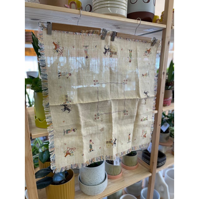 Vintage embroidered tablecloth featuring a natural linen ground with hand-stitched figural and decorative motifs. The...