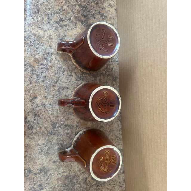 A handsome set of five vintage stoneware coffee mugs featuring a rich brown drip glaze with warm, earthy undertones. These...