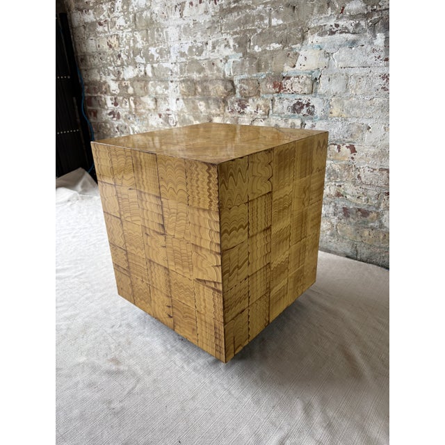 A striking sculptural side table featuring a richly patterned patchwork of hand painted squares in a warm honey toned...
