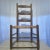 Three slat ladder back chair. The seat appears to have been redone at some point. The finials at the top of the back look...