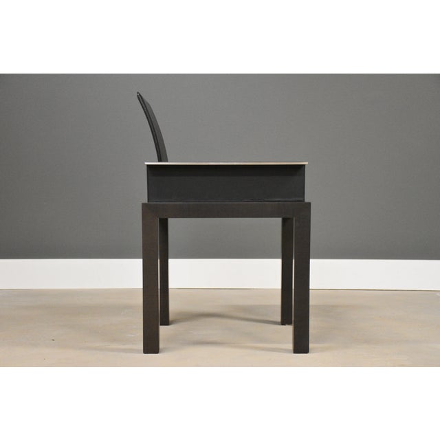 A modern black leather walnut color Haiku dining chair made by Tresserra. Marked with the back emblem. Made in Spain....