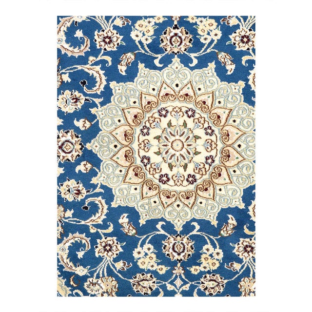 Persian Nain rugs are renowned for their detail and fine use of outlining along the central motifs. Breaking from the...