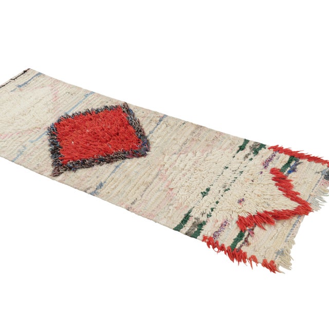 Hand-knotted in wool and originating from Morocco circa 1950-1960, this 2x5 vintage Moroccan rug is an extremely rare...