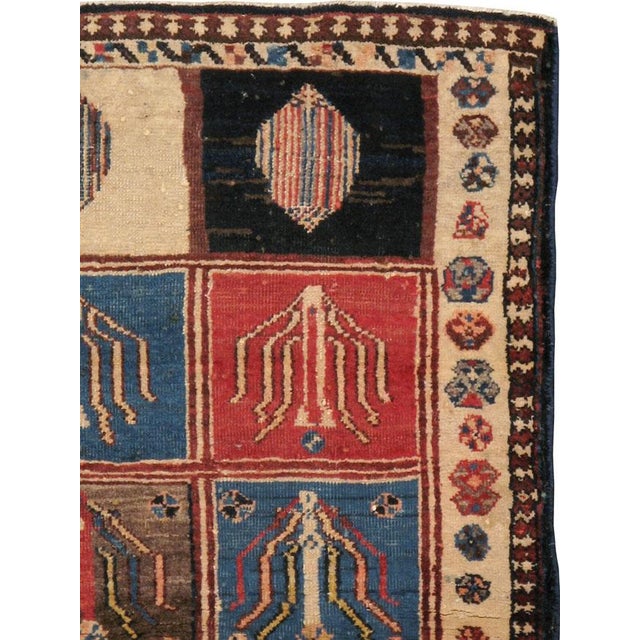 An antique Persian Bakhtiari carpet from the second quarter of the 20th century.