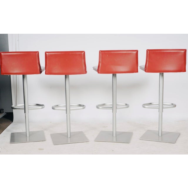 A striking set of four Bottega adjustable bar stools by Frag, designed by Renzo Fauciglietti and Graziella Bianchi....