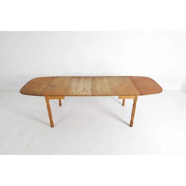 A Danish mid-century modern solid wood table with removable (iron hinged) drop leaves and extension leaves. The table is...