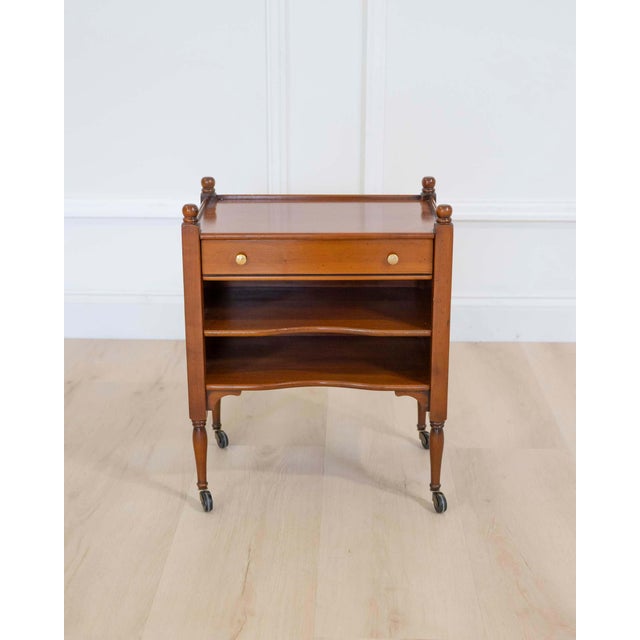 Made in France in the twentieth century, this small cherrywood bedside table has a drawer opening at the front, two...