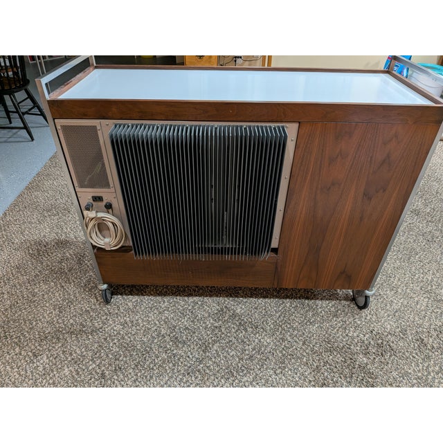 Buffet bar is walnut with white laminate on top with metal handle on each end to which the wheels are attached