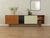 A classic sideboard by Lothar Wegner from the 1960s. High-quality walnut veneer body with two black and cream-white glass...