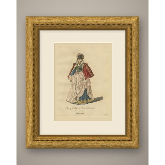 An original antique print, a copper engraving colored by hand, lettered "habit of a lady of quality in france." a woman...