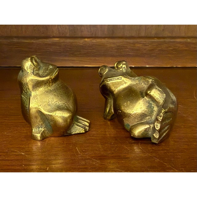 A pair of super cute chunky brass frogs. One is sitting, one is lounging.