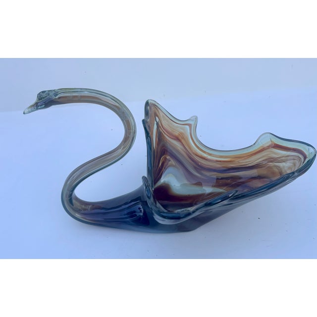 This Mid-Century Modern hand-blown glass bowl in the shape of an elegant swan features an amber and brown slag glass swirl...