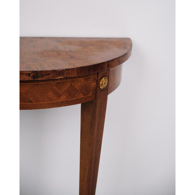 Antique console table made in fruitwood with marquetry from around the 1880s. The table features tapered legs and...