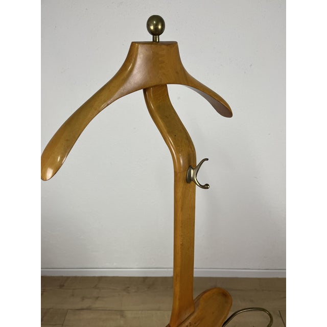Wooden valet stand with anthropomorphic brass details, designed and produced by Fratelli Reguitti in the 1960s. The valet...