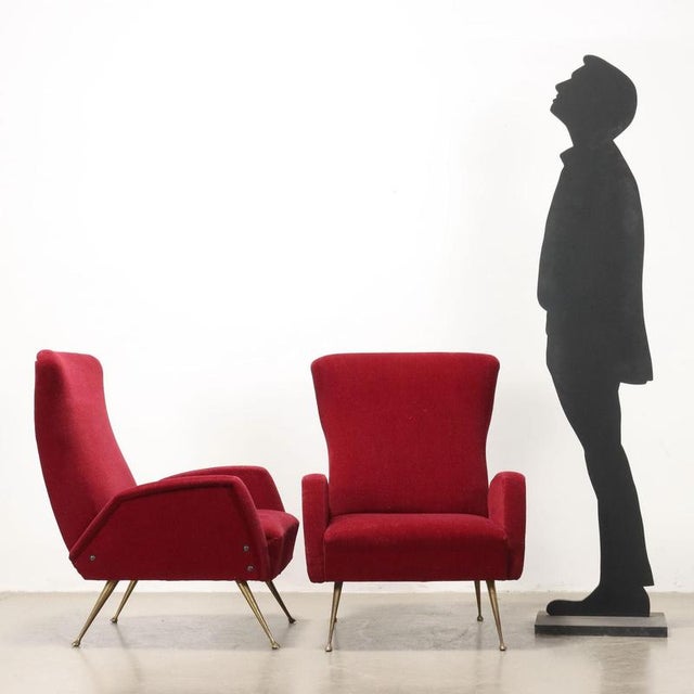 Pair of armchairs, foam padding, original period fabric upholstery, brass legs. This piece is attributed to the mentioned...