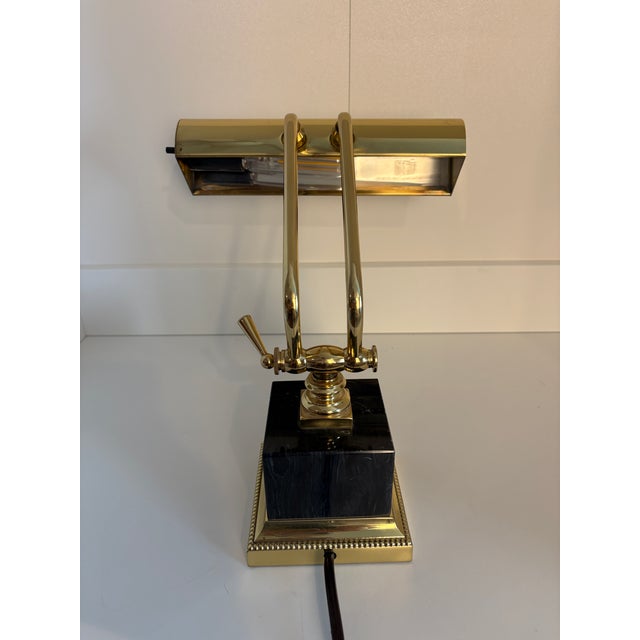 This Piano/Desk Lamp from House of Troy has a polished brass finish. Base is a heavy black marble style cube. Uses a...