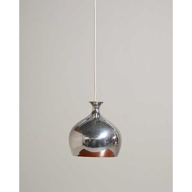 Chromed metal diffuser with a globular silhouette, tapered neck, and white lacquered interior. Scandinavia, 1960s. Pendant...