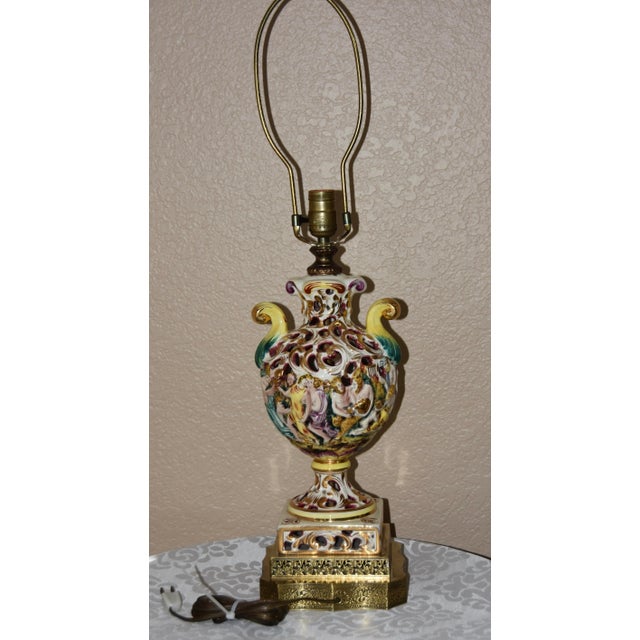 Vintage. Capodimonte lamp with brass base. the 3-dimensional figures and Interactive social scene in high relief with...