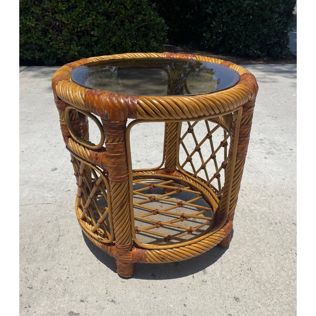 Cute vintage rattan side or end table featuring leather bindings throughout. The sides have a lattice design with 2...