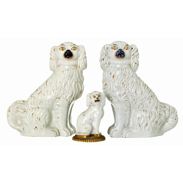 Pair of dogs and an english dog, 19th century in molded and embossed ceramic, one sitting on a gilded metal base. Small...