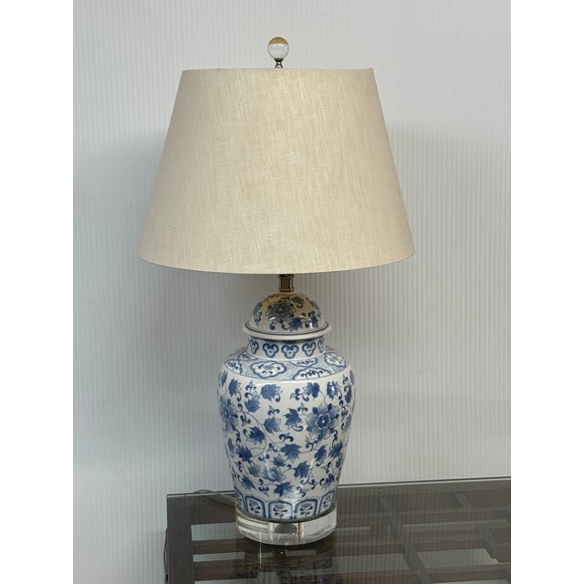 Design Plus Gallery presents a Blue + White Porcelain Table Lamp with Asian Influence. The white lamp has foliage in blue...