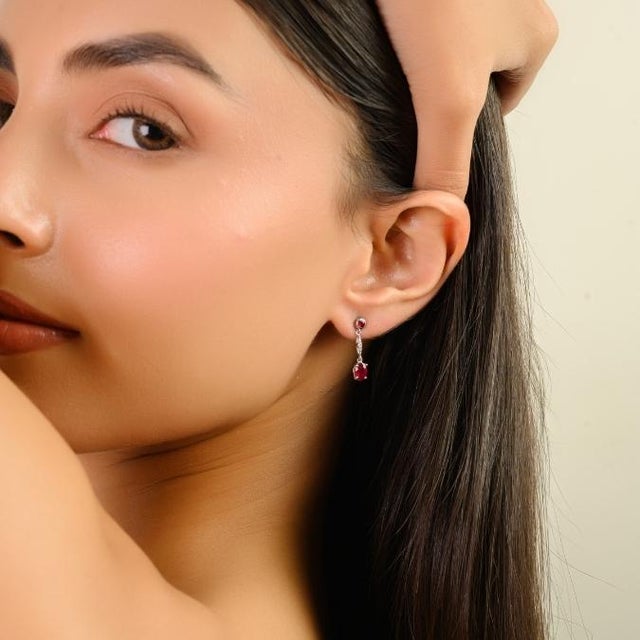 These elegant drop dangle earrings feature four oval and round-cut natural rubies totaling 1.35 carats, set in rich 14K...