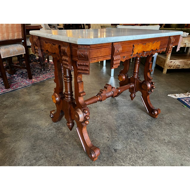 This exceptional 19th-century Renaissance Revival parlor table features a robust trestle-form base with intricate...