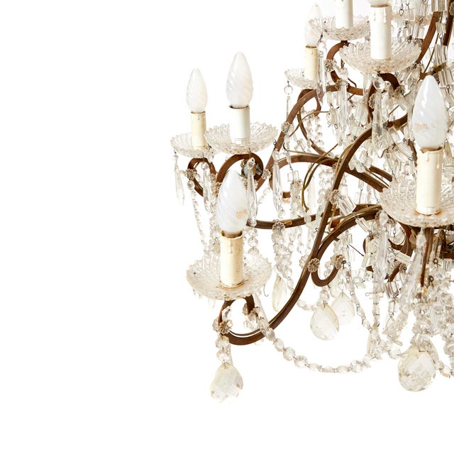 Scenographic chandelier in welded brass and glass, Maria Theresa style, with molded beads and drop shape glass pendants....