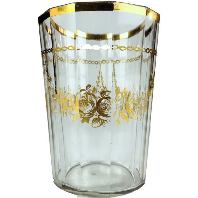 Antique Bohemian gilded glass cup from the 18th century. It has a polygonal shape with 13 sides and a gilded rim, a...