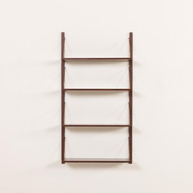 A minimalist wall-mounted shelving system very resemble to the iconic designs of poul cadovius from the 1960s, made in...
